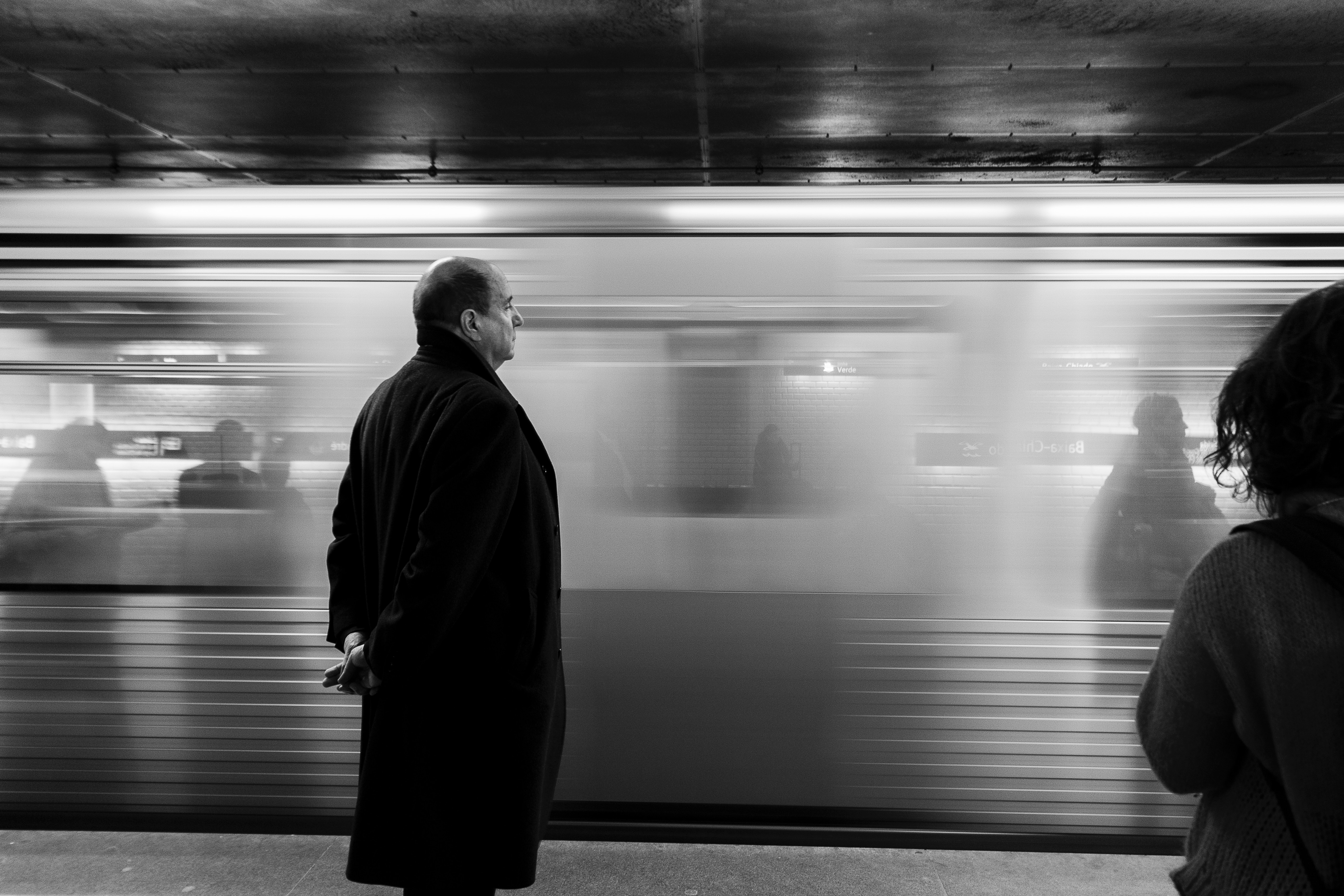 Picture of a man standing in front of a moving train.